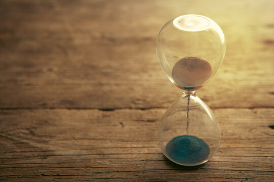 Hourglass on wooden background. Time passing concept.