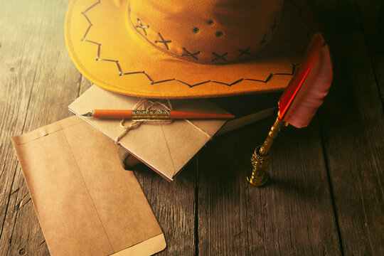Vintage still life with old book, pen, feather and hat