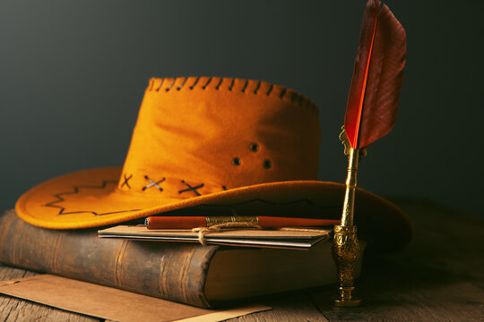 Vintage still life with old book, pen, feather and hat