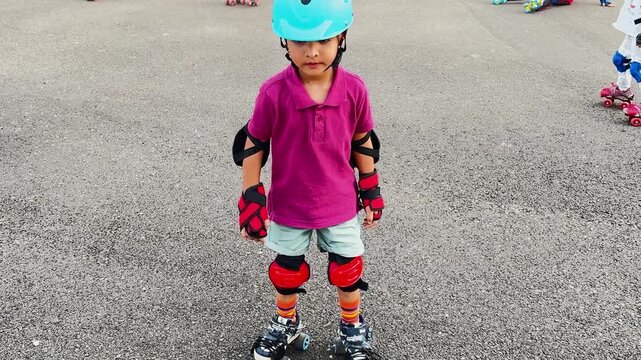 Young Child Wearing Protective Helmet and learning Skates Outdoors