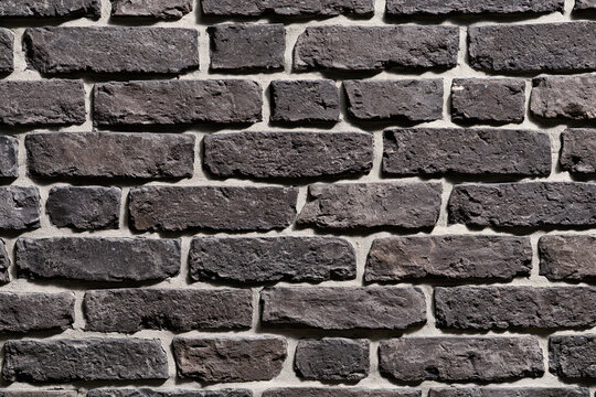 Aged Charcoal Grey Brick Wall Background Texture with Rough Masonry Surface