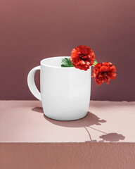 White mug with red flowers on pink tabletop against mauve wall © Rawpixel.com