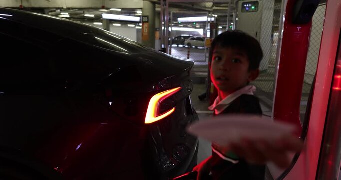 Little boy enjoy use EV car charge indoor supermarket car park transport technology