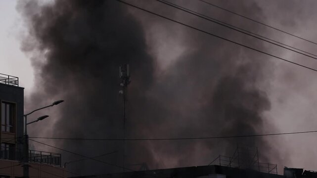 A shopping mall building engulfed in flames and smoke following a direct hit by a drone-launched missile. Smoke and fire after a drone attack in Ukraine the war