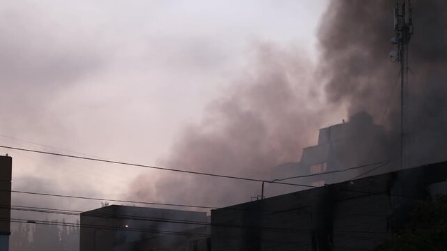 A shopping mall building engulfed in flames and smoke following a direct hit by a drone-launched missile. Smoke and fire after a drone attack in Ukraine the war
