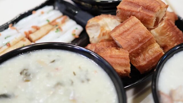 Close up of traditional Cantonese breakfast with congee and fried dough sticks.