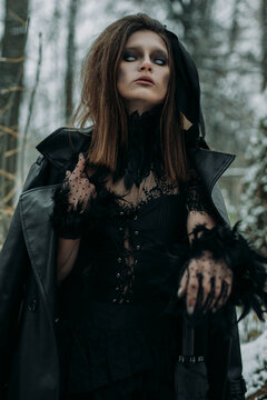 Mysterious witch walks in night forest. fog smoke, haze.Goth scary queen