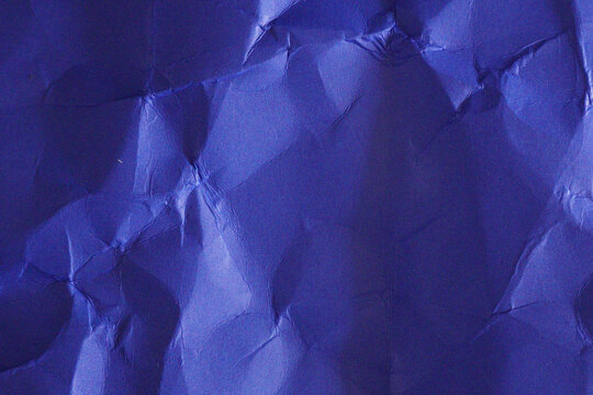 Close-up view of crumpled blue paper with intricate folds