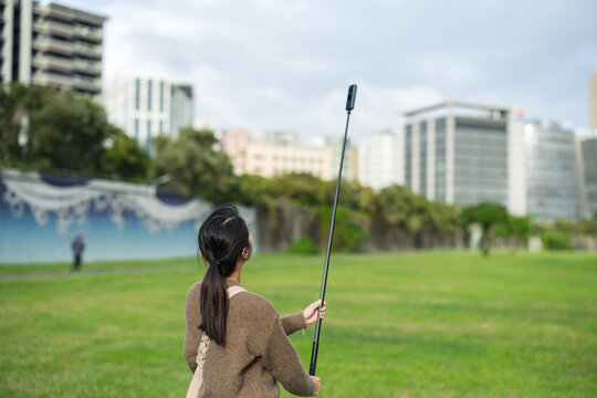 Woman using 360 degree camera outdoors