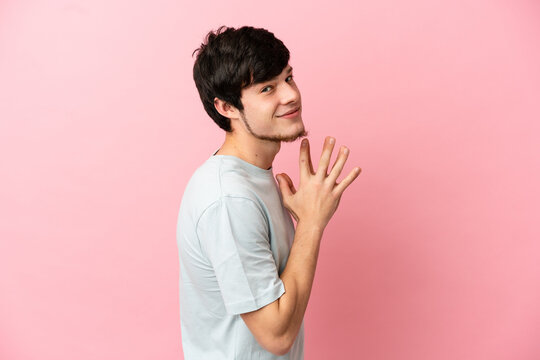 Young Russian man isolated on pink background scheming something