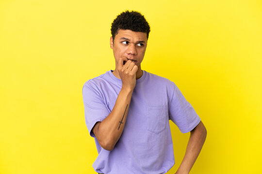 Young African American man isolated on yellow background nervous and scared