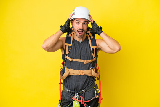 Young caucasian rock climber man isolated on yellow background with surprise expression