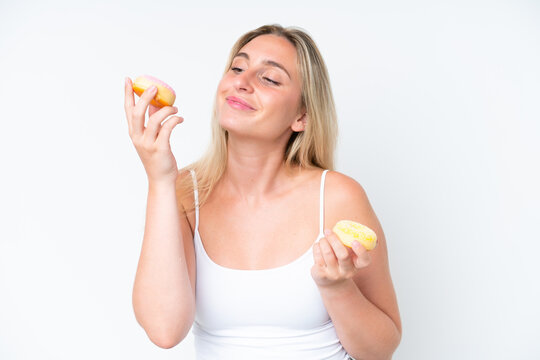 Young caucasian woman isolated on white background holding donuts with happy expression