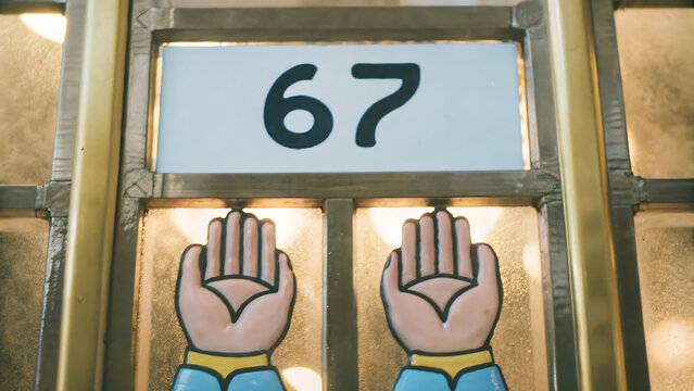 Number 67 sign displayed above decorative stained glass window panels