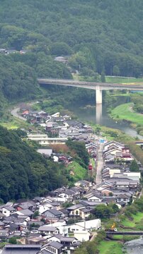 竹田城跡から望む円山川と赤いローカル線が走る麓の街並みの縦動画