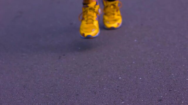 Close up of marathon athletes legs and feet as they run on the pavement