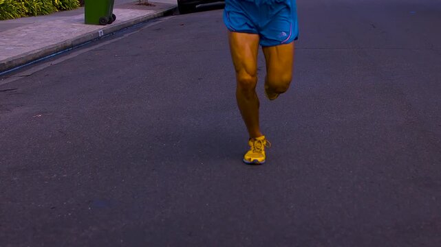 Close up of ultra runners legs as they workout on the pavement