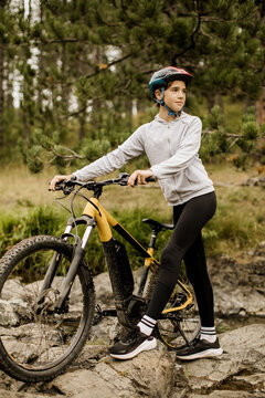 Young cyclist enjoys a peaceful moment in nature surrounded by trees