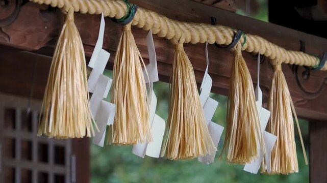 風に揺れる稲荷神社の注連縄