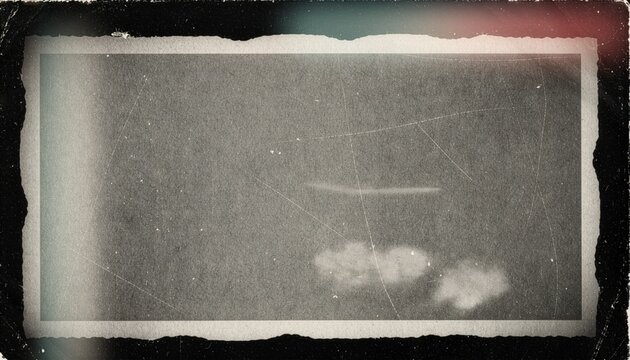 Vintage dark monochrome photo border texture overlay with ripped paper edges and dusty film scratches captured via scanner.