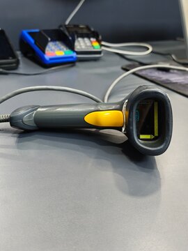 Front view of handheld barcode scanner on cashier checkout counter desk
