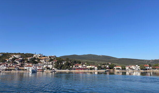 The unmatched beauty of Greek settlements nestled in Aegean bays, seen during a sea voyage on a sunny summer day.