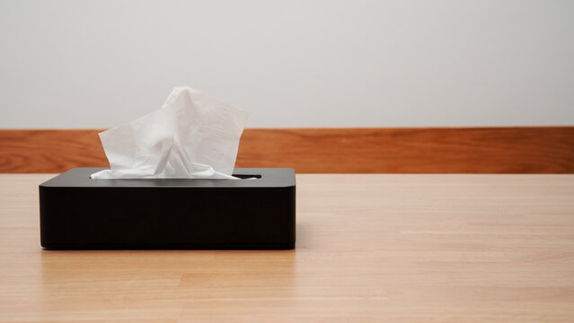 Hand pulling a tissue from a box