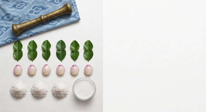 Minimalist knolling flat lay of kaffir lime leaves, shallots, and coconut cream