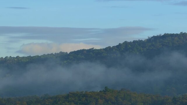 Morning mist and fog rolling over tropical forest mountains in Thailand