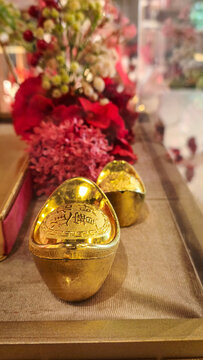 Gold Sycee Ingot Sangjit Ceremony Display. Traditional gold sycee ingots adorned with red flowers for a Chinese Sangjit engagement ceremony. Translate : Ushering in wealth and bringing in treasures