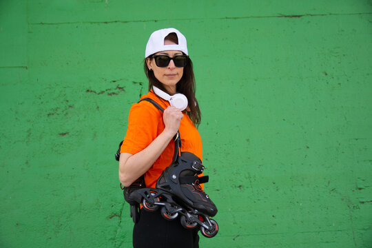 Woman carrying rollerblades ready for urban skating adventure