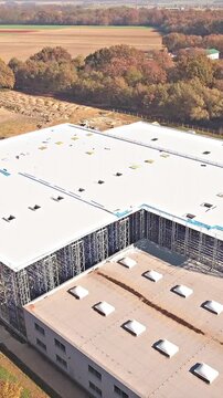 Drone ascending over new industrial warehouse zooming out