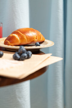 Golden croissant with blueberries on a cozy breakfast table