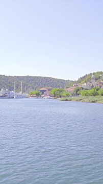 Sailing on river with focus on riverbank and small village