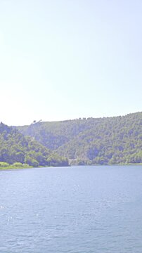 Sailing on wide river between green hills