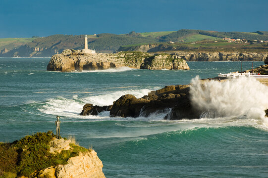 Rough sea and waves around Mouro Island Lighthouse in Santander, Spain