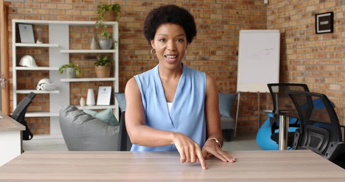 Close up of people talking to the camera, woman in office pointing at desk, discussing work during m