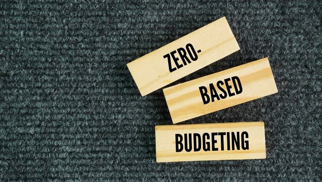 Wood with the word Zero-based budgeting is a financial method where your total income minus your total expenses equals zero, meaning every single dollar is assigned a specific job.