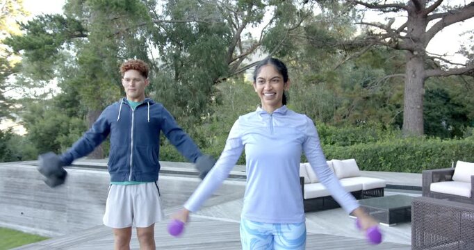 Lifestyle videos outdoor of people doing activities , exercising outdoors, man and woman lifting dum