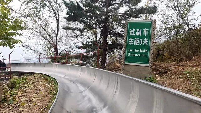 First person perspective view of tourist sliding down on toboggan from Mutianyu section of China Great Wall
