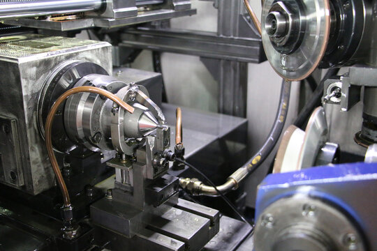 Precision CNC grinding machine working on metal part in industrial workshop