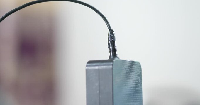 Close up of repaired power adapter cable wrapped with black electrical tape