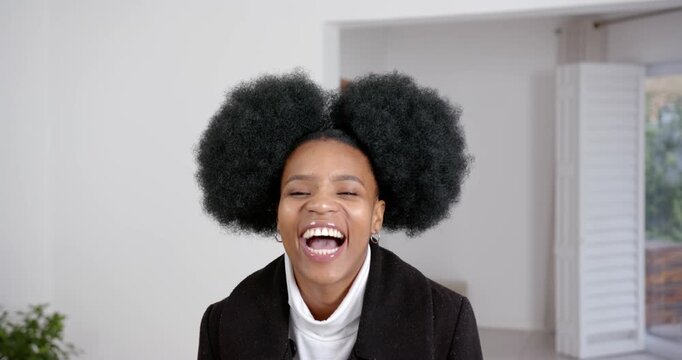 High speed photography for dynamic scenes, smiling woman with afro hairstyle laughing, wearing black