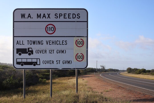 Large white maximum speeds regulations road sign on highway landscape in rural Western Australia. Highlighting transport speed limits,  caution warming. Towing and heavy vehicles. Copy space