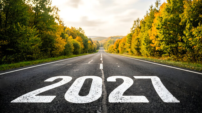The year 2027 painted on an empty asphalt road leading into the autumn forest