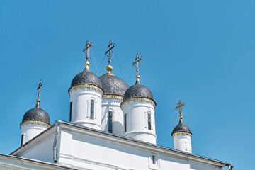 Domes of White Trinity Cathedral with golden crosses in Tver Russia against blue sky © IrinaK