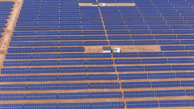 Aerial View of a Large Scale Solar Farm with Rows of Photovoltaic Panels