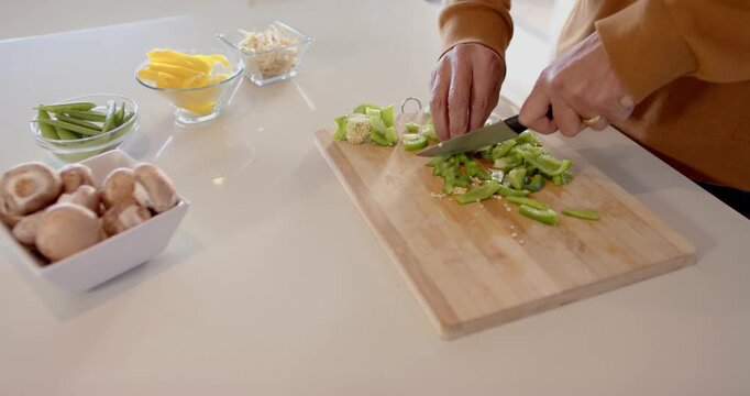 Chopping fresh vegetables on wooden board in modern kitchen for healthy meal