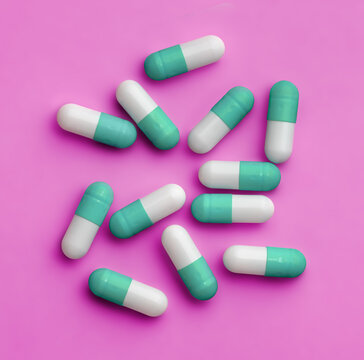 Blue white pills on a pink background. Directly above