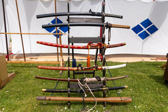 Traditionelle japanische Samuraischwerter auf einem h&ouml;lzernen Waffenst&auml;nder bei einer historischen Ausstellung im Freien